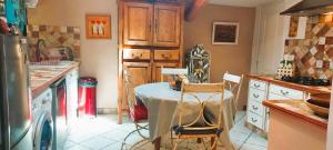 une cuisine avec une table et des chaises. dans l'établissement Mas de l'Oratoire, à Saint-Rémy-de-Provence