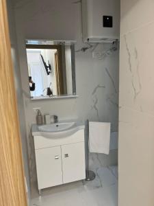 une salle de bains blanche avec un lavabo et un miroir dans l'établissement Villa Milano Apt. n. 5, à Milan 4 autres photos