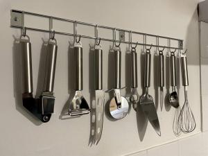 a bunch of utensils hanging on a rack in a kitchen at Le Studio de Ella in Bouxwiller
