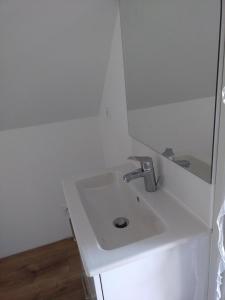 La salle de bains blanche est pourvue d'un lavabo et d'un miroir. dans l'établissement A la campagne, au calme, à Montérolier