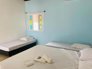- une chambre avec 2 lits et des serviettes à l'étage dans l'établissement Pousada Riviera, à Caraguatatuba