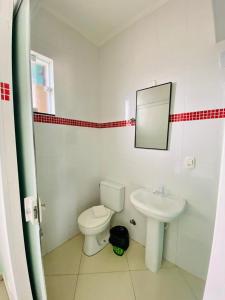 łazienka z toaletą i umywalką w obiekcie Pousada Riviera w mieście Caraguatatuba