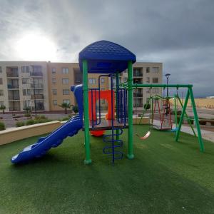 un parque infantil con tobogán en Departamento full equipado con vista al mar, en Caldera
