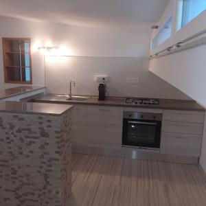 een lege keuken met een wastafel en een fornuis bij Appartamento Monastir R2659 in Monastir