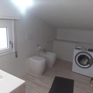een badkamer met een toilet en een wasmachine bij Appartamento Monastir R2659 in Monastir