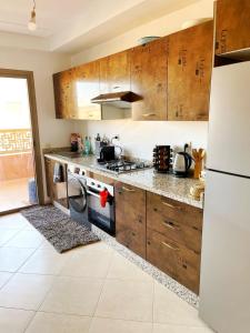 马拉喀什Superbe appartement en résidence avec piscines的配有木质橱柜和白色冰箱的厨房