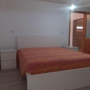 een slaapkamer met een bed met een oranje sprei bij Appartamento Monastir R2659 in Monastir