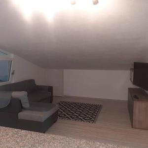 een woonkamer met een bank en een tv bij Appartamento Monastir R2659 in Monastir