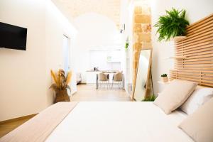 a bedroom with a white bed and a dining room at Victory Suite 31 in Brindisi