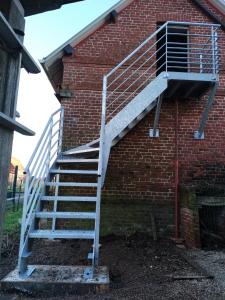 a staircase on the side of a brick building at A la campagne, au calme in Montérolier