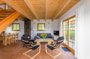 a living room with a table and chairs at Domki Pod Dębem in Błądzonka