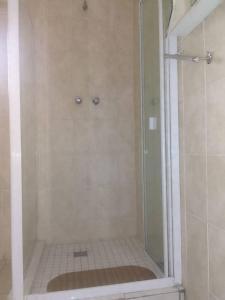 um chuveiro com uma porta de vidro na casa de banho em Oteng Guest House em Belfast