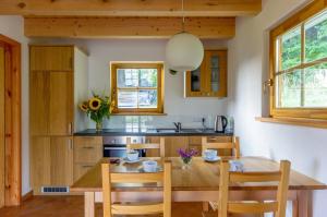 a kitchen with a wooden dining room table and chairs at Domki Pod Dębem in Błądzonka