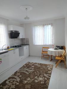 uma cozinha branca com uma mesa e um estofados de estandartes em Yomra Villa Konaklama Günlük Kiralık em Yomra