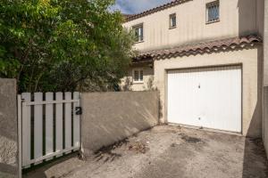a white garage door in front of a house at Villa Tika in Béziers