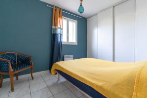 - une chambre avec un lit, une chaise et une fenêtre dans l'établissement Villa Tika, à Béziers