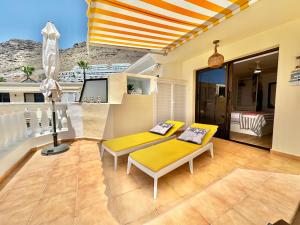 een woonkamer met een gele bank en een balkon bij Costa Canaria in Santiago del Teide