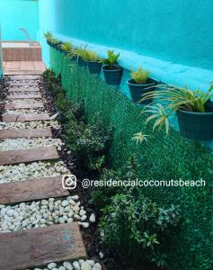 einen Garten mit einem Zaun und Pflanzen in der Unterkunft Residencial Coconut's Beach in Ilha Comprida + 12 Fotos