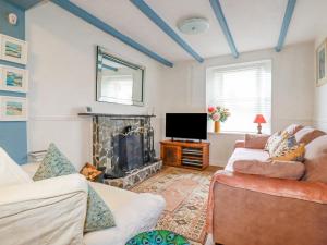 a living room with two couches and a fireplace at 4 Greenbank Terrace in St Austell