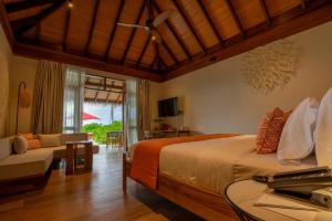 a bedroom with a bed and a couch and a table at Barceló Whale Lagoon Maldives in Machchafushi