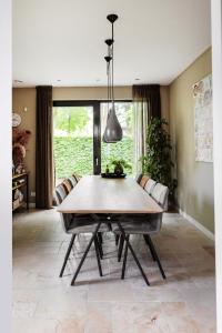 a dining room with a wooden table and chairs at Avellano in Helmond