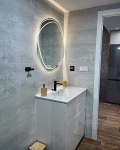 La salle de bains est pourvue d'un lavabo blanc et d'un miroir. dans l'établissement ADOME Apartment Nautico IV, à Santa Pola