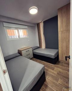 - une petite chambre avec 2 lits et une fenêtre dans l'établissement ADOME Apartment Nautico IV, à Santa Pola