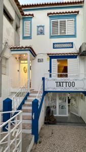 un edificio azul y blanco con escaleras delante en Hostel da Praia, en Portimão