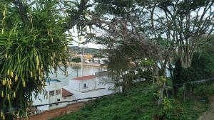 Biała łódź w wodzie obok drzew w obiekcie Apartamento Vista Panoramica w mieście Triunfo