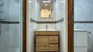 a bathroom with a sink and a mirror at Hostel da Praia in Portimão