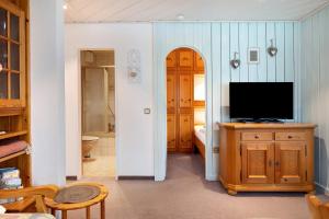ein Wohnzimmer mit einem TV und einem Badezimmer in der Unterkunft Oskar in Titisee-Neustadt