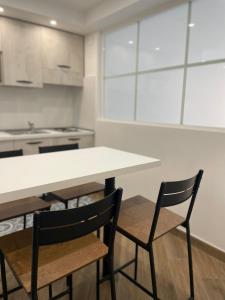 Maiolica Apartment في كالتانيسيتا: مطبخ بطاولة بيضاء وكرسيين