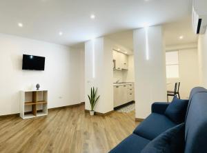 Maiolica Apartment في كالتانيسيتا: غرفة معيشة مع أريكة زرقاء ومطبخ