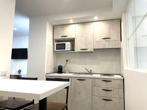 a small kitchen with a sink and a microwave at Maiolica Apartment in Caltanissetta