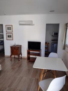 uma sala de estar com uma mesa branca e uma televisão em B&B Garden Atelier em La Cumbre