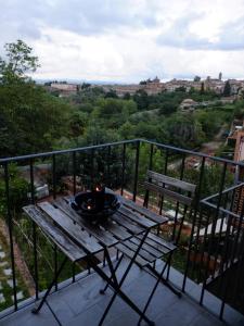un tavolo e una panca sul balcone con vista di Casa Baroncelli a Siena