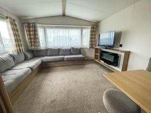 a living room with a couch and a flat screen tv at Superb 6 Berth Caravan At Martello Beach, Near Clacton-on-sea Ref 29008mc in Clacton-on-Sea