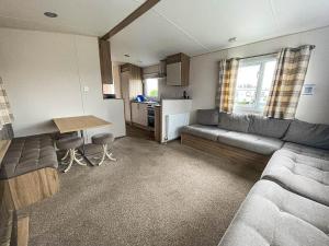 a living room with a couch and a table at Superb 6 Berth Caravan At Martello Beach, Near Clacton-on-sea Ref 29008mc in Clacton-on-Sea