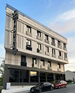 a building with two cars parked in front of it at Heaven Premium Hotel İstanbul Airport in Arnavutköy