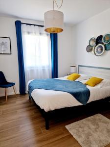 1 dormitorio con 1 cama grande y cortinas azules en Le Gîte City Haut de gamme, Jardin, Piscine, en Gabriac