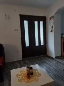 uma sala de estar com uma mesa em frente a uma porta em Apartman Rajac em Takovo