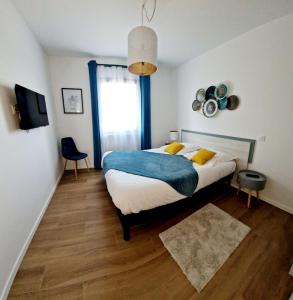 1 dormitorio con 1 cama con almohadas azules y amarillas en Le Gîte City Haut de gamme, Jardin, Piscine, en Gabriac