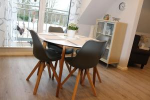einen Esstisch mit 4 Stühlen in einem Zimmer in der Unterkunft Kleine Auszeit, Schöne neue Ferienwohnung in Bitburg