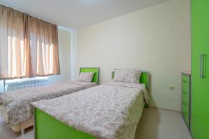 2 camas en una habitación con verde y blanco en Апартамент Амбра, en Sandanski