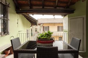 une table avec des chaises et une plante en pot sur un balcon dans l'établissement Nido di Gemma, à Ispra