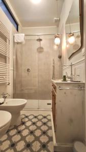 een badkamer met een douche, een wastafel en een toilet bij Residenza d'Epoca CAVALIERE in Bibbona