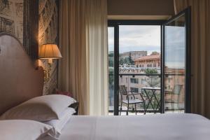 um quarto com uma cama e vista para uma varanda em Starhotels Michelangelo Rome em Roma