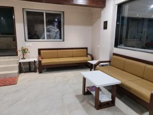 Sala de estar con 2 sofás y mesa en Hotel Darshan Grand, en Kolhapur