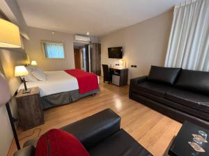 ein Hotelzimmer mit einem Bett und einem Sofa in der Unterkunft Bue Hotel in Buenos Aires