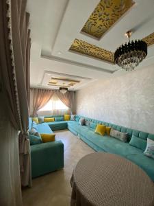 uma sala de estar com sofás azuis e uma mesa em La casa de Halima em Sidi Ifni